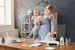 Young mother talking on phone and spending time with baby