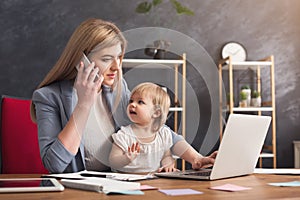 Young mother talking on phone and spending time with baby