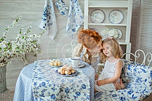 Young Mother Talks With Her Daughter At Kitchen