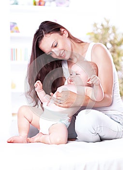 Young mother teaches baby to stand. the concept of motherhood