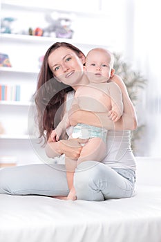 Young mother teaches baby to stand. the concept of motherhood