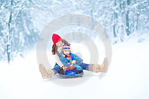 Young mother and toddler daughter enjoying sledge photo
