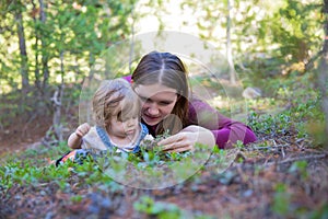 Young mother and toddler girl lying on the ground looking down