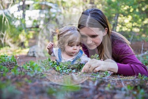 Young mother and toddler girl lying on the ground looking down