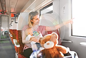 Young mother travelling with baby by train.