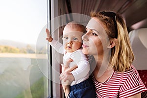 Young mother travelling with baby by train.