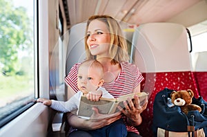 Young mother travelling with baby by train.