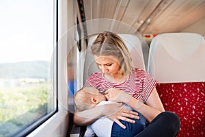 Young mother travelling with baby by train.