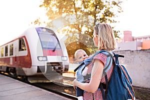 Young mother travelling with baby by train.