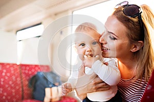 Young mother travelling with baby by train.