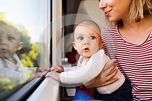 Young mother travelling with baby by train.