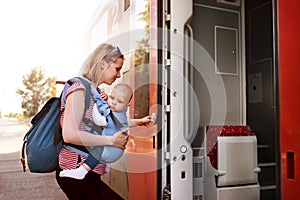 Young mother travelling with baby by train.