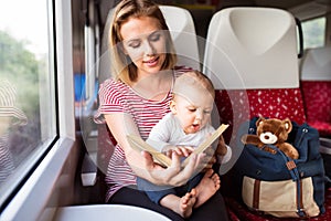 Young mother travelling with baby by train.