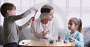 Young mother and two children molding modeling clay at home