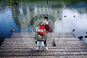 Young mother walking with her cute little daughter outside in urban park