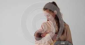 Young mother watching her baby son sleeping in arms