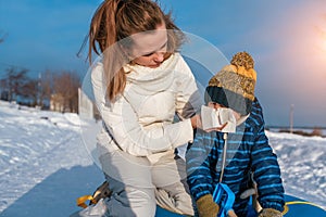 Young mother wipes snot her baby. In winter in the fresh air. The concept of health and child care. Colds, runny nose