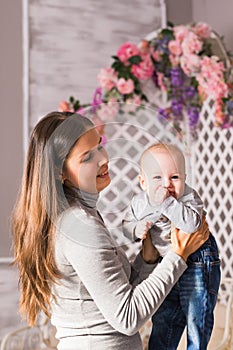 Young mother woman holding and hugging in her arms child baby kid boy smilling laughing