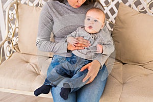 Young mother woman holding and hugging in her arms child baby kid boy smilling laughing