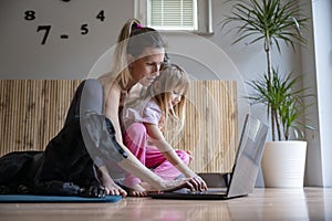 Young mother working from home with her toddler daughter in her lap photo