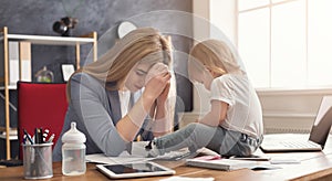 Young mother working and spending time with baby