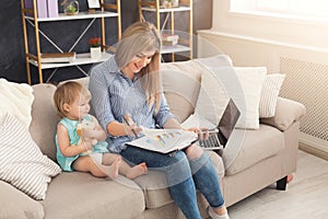 Young mother working and spending time with baby