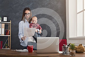 Young mother working and spending time with baby