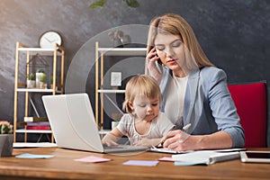 Young mother working and spending time with baby