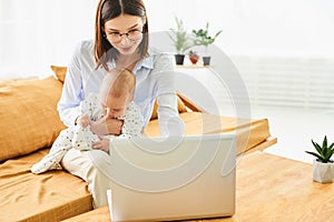 A young mother works from home with her baby