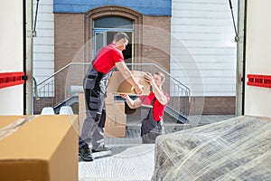 Young Movers Unloading The Boxes In The Van photo