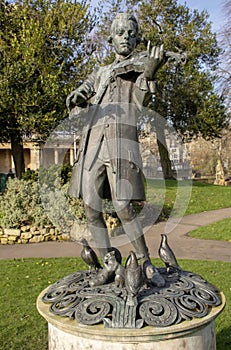 Young Mozart statue at a park with cloudy sky