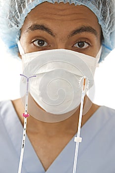 Young Mulatto doctor holding two types of IUD birth control copper coil devices in his hands