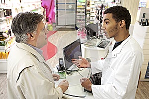 Young Mulatto male pharmacist speaking with a customer