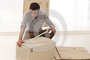 Young Mulatto man closing a moving box