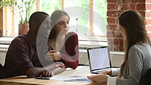 Young multi-ethnic couple planning mortgage meeting with real estate agent