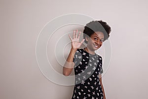 Young multi racial girl with afro hair smiling and waving