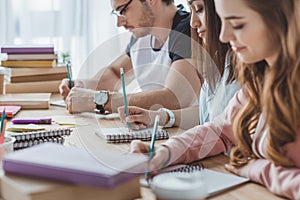 young multicultural students writing