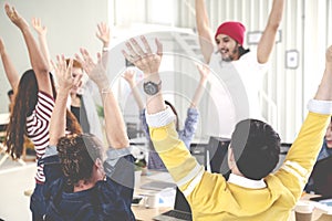 Young multiethnic diverse creative asian group huddle and high five hands together in office workshop with success or empower