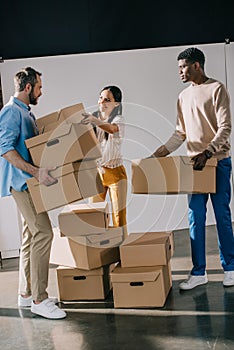 young multiethnic people holding cardboard boxes during relocation