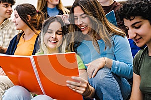 Young multiracial friends studying together outside university