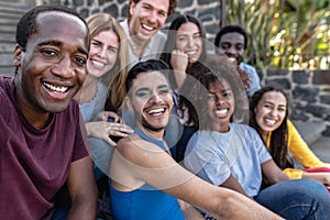 Young multiracial group of friends taking selfie sitting on urban stairs