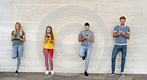 Young multiracial group of friends using mobile smartphone outdoor