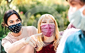 Young multiracial people having fun together wearing face mask - New normal lifestyle concept with happy friends sharing free time