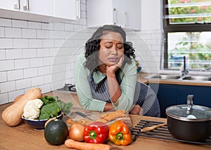 A young multiracial woman is tired and uninspired while preparing dinner photo