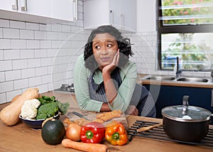 A young multiracial woman is tired and uninspired while preparing dinner photo