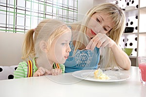 Young mum feeds the daughter in cafe