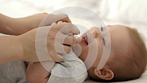 Young mum playing with her baby girl in bedroom