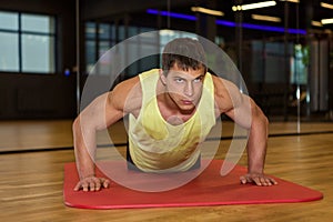 Young muscle man doing push ups