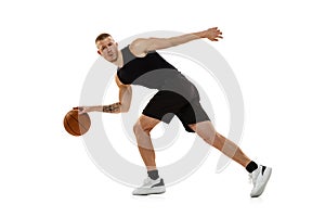 Young muscled man, basketball player practicing with ball isolated on white studio background. Sport, motion, activity