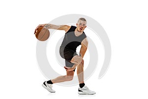 Young muscled man, basketball player practicing with ball isolated on white studio background. Sport, motion, activity